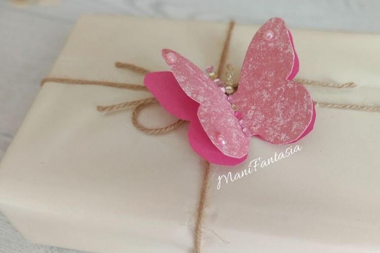 impacchettare un regalo con farfalle di carta